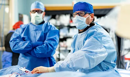 Dr. Chris Metzger performing a cardiovascular surgery procedure in an operating room